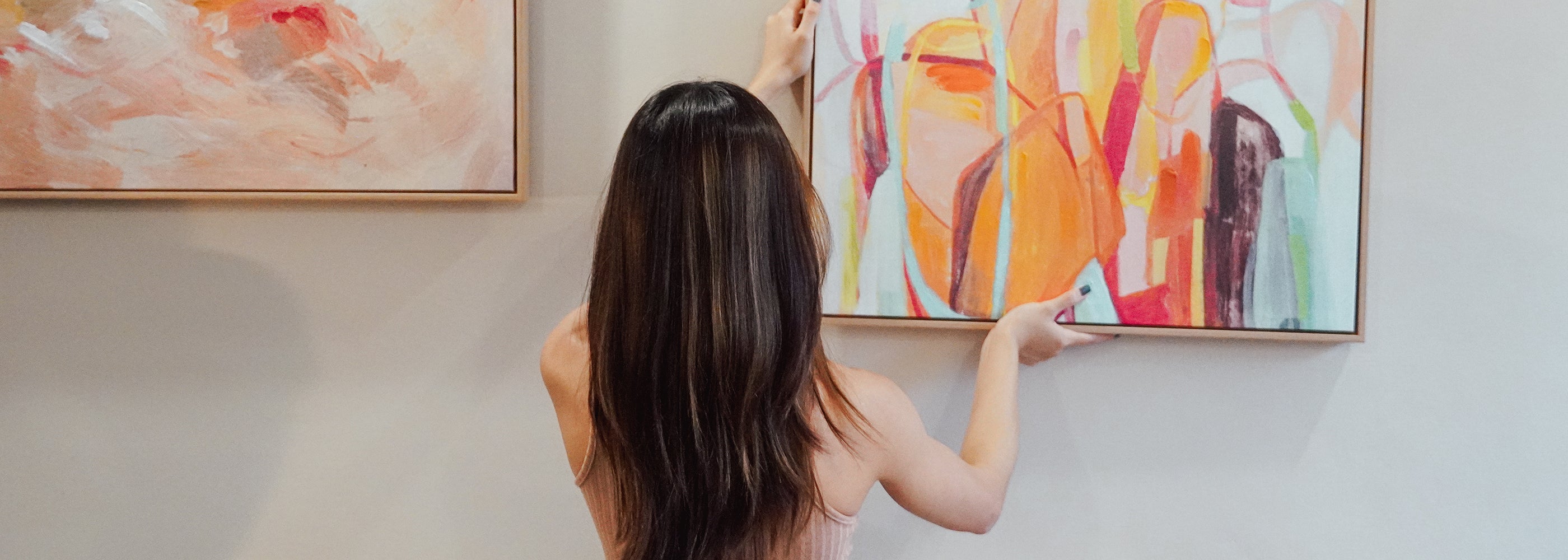girl hanging wall art painting at home