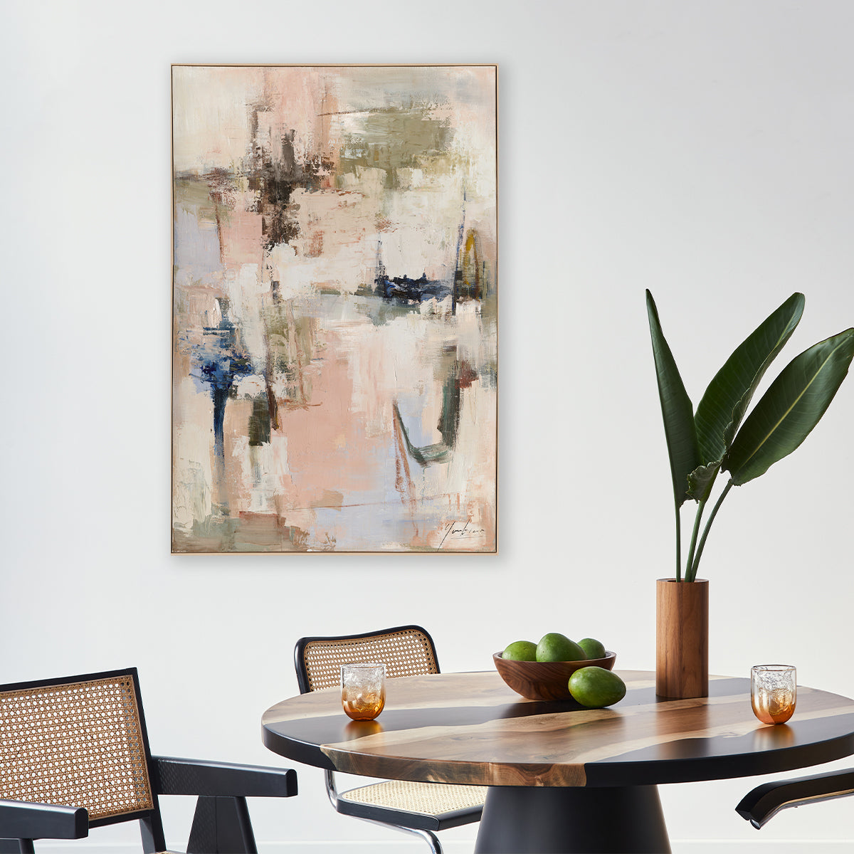 Abstract painting on a wall above a dining table with a plant and fruit bowl.